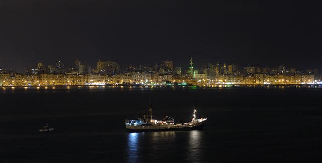 The expedition ship Princess Duda in front of Alexandria’s night skyline.