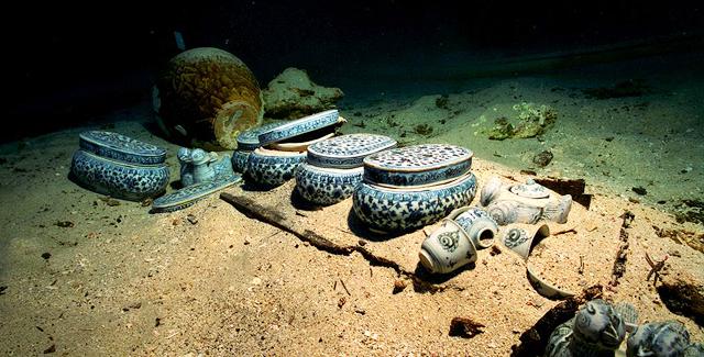 Porcelain dishes in blue and white appear after the sediment has been removed from the wreck of the Lena Shoal junk.